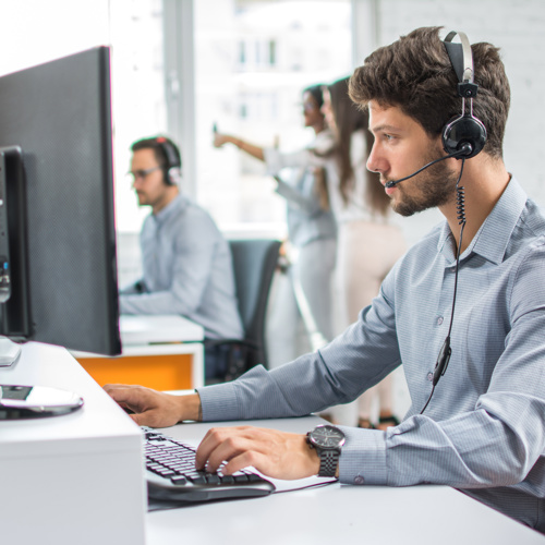 Man on service desk, with a headset on.